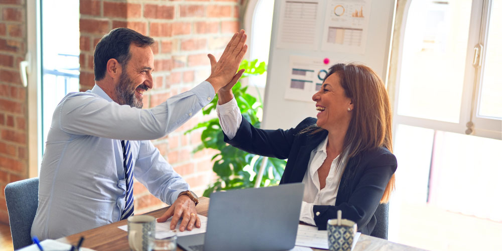 Zwei Menschen geben sich glücklich ein Highfive