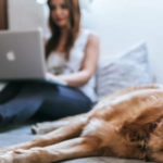Frau mit Hund am Laptop