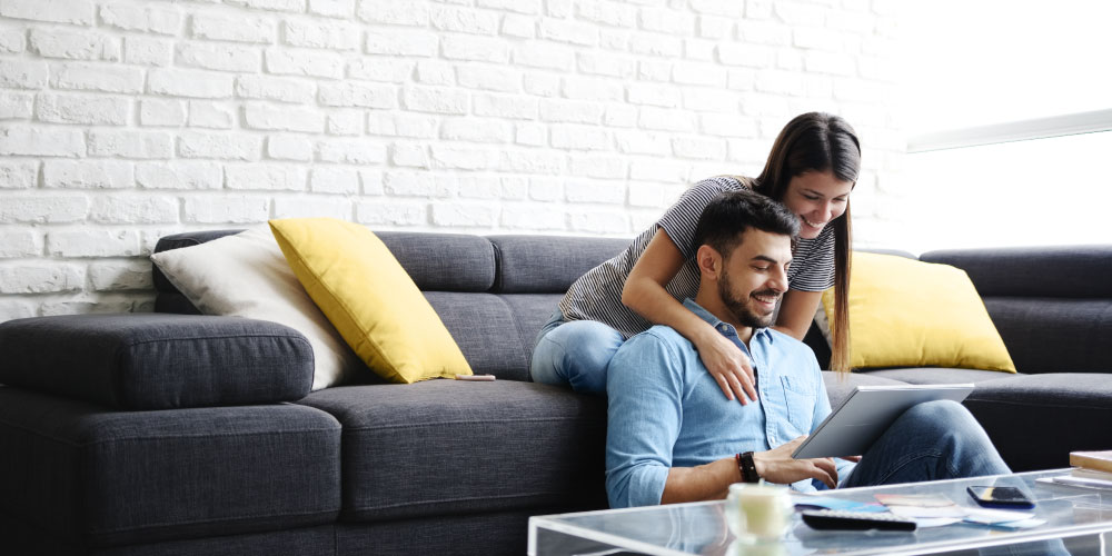 Ein Pärchen mit Laptop auf einem Sofa