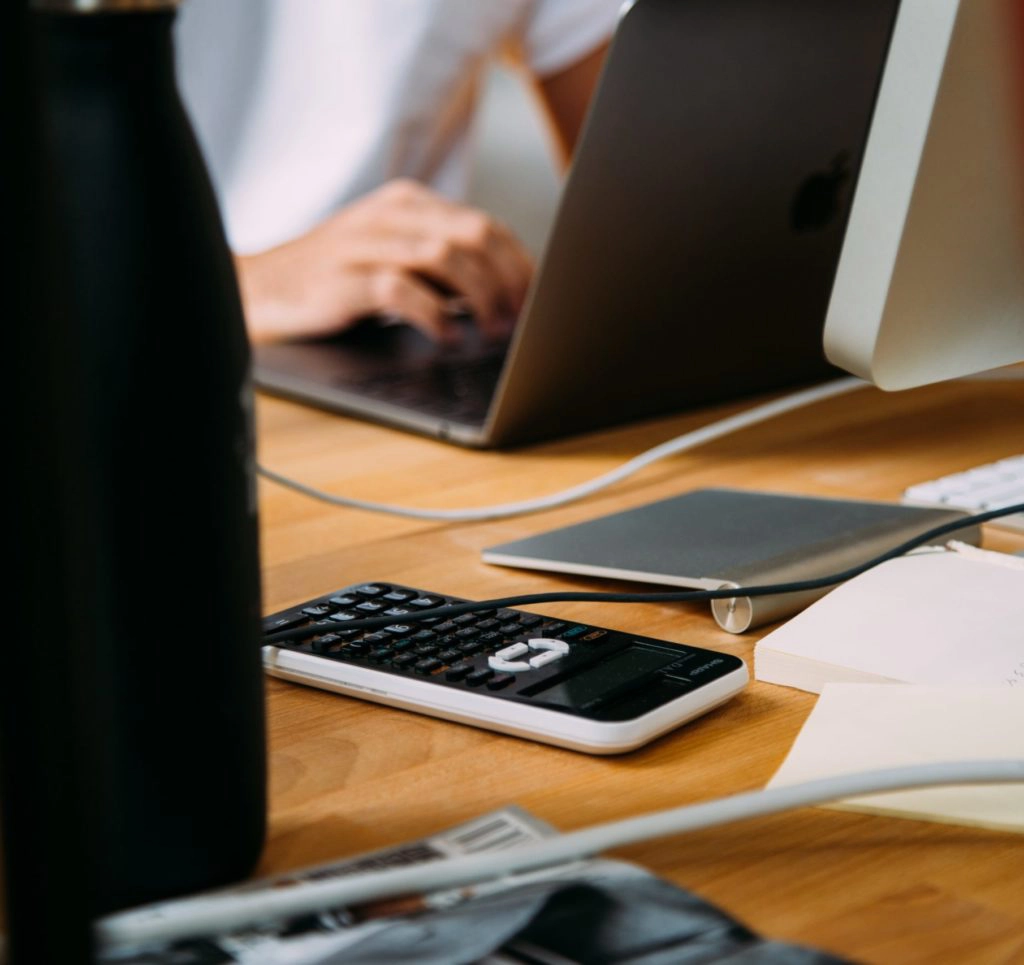 Eine Person sitzt am Laptop und arbeitet an einer Immobilienfinanzierung.