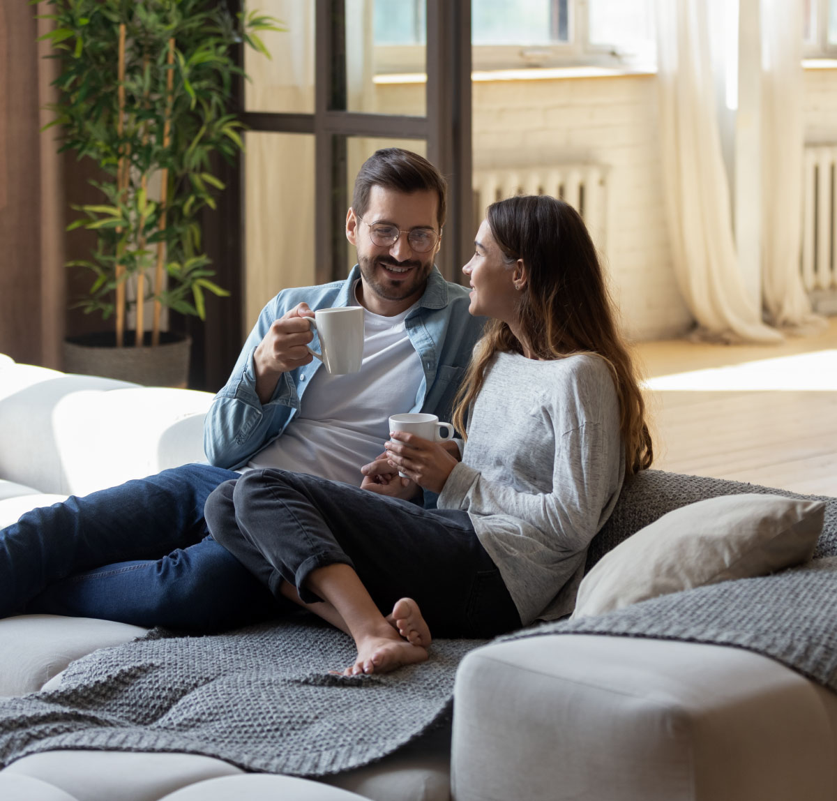 Pärchen trinkt zusammen Kaffee auf einem Sofa