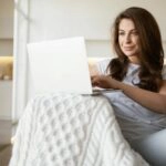 Eine Frau recherchiert im Internet, wie sie einen Baukredit umschulden kann