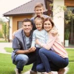 Eine Familie vor ihrem Haus, sie hat gravierendeFehler bei der Eigenheimfinanzierung vermieden