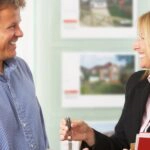 Eine Immobilienmaklerin übergibt den Hausschlüssel, für ihre Bezahlung gilt grundsätzlich das Bestellerprinzip