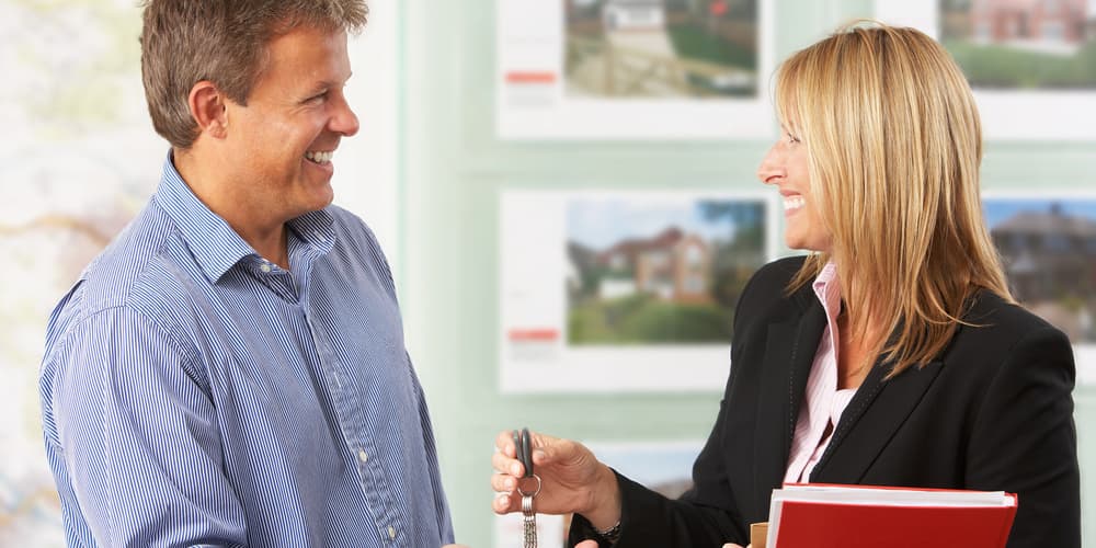 Eine Immobilienmaklerin übergibt den Hausschlüssel, für ihre Bezahlung gilt grundsätzlich das Bestellerprinzip