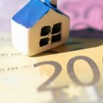 Ein Haus auf Geldscheinen als Symbol für eine von der Bank geforderte Nachbesicherung