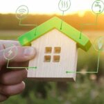Ein Modellhaus mit verschiedenen Symbolen, wie hoch sind die Erschließungskosten für ein Baugrundstück?