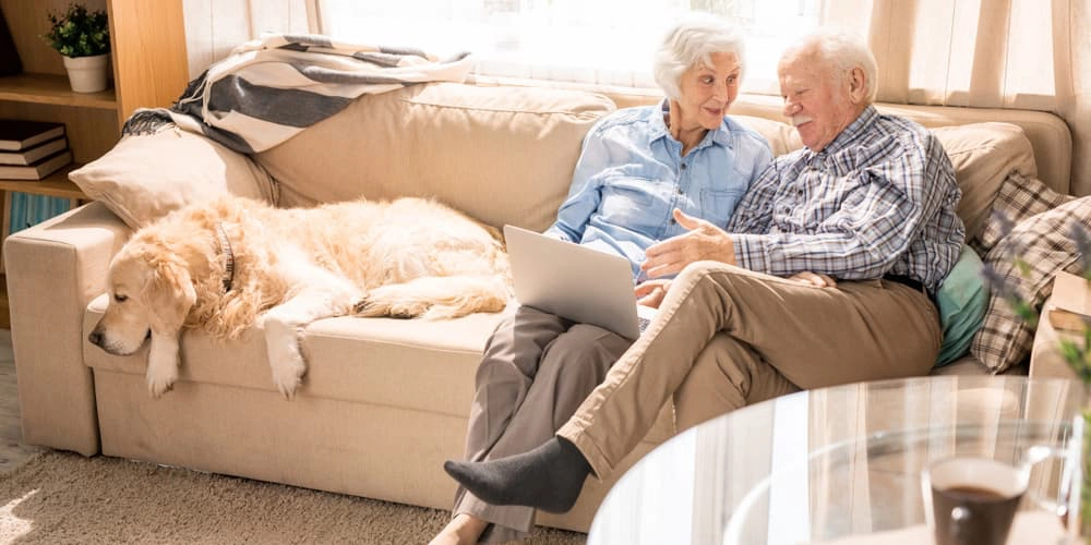 Ein älteres Ehepaar sitzt auf dem Sofa, was ist altersgerechtes Wohnen?