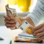Ein Mann mit vielen Geldscheinen als Symbol für seine Bonität