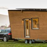 Ein mobiles Tiny House an einem Auto