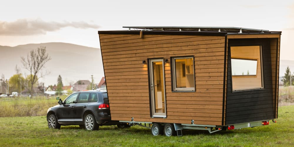 Ein mobiles Tiny House an einem Auto