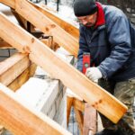 Ein Mann beim Hausbau im Winter