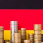 Eine deutsche Flagge und Münzen als Symol für staatliche Eigenheimförderung