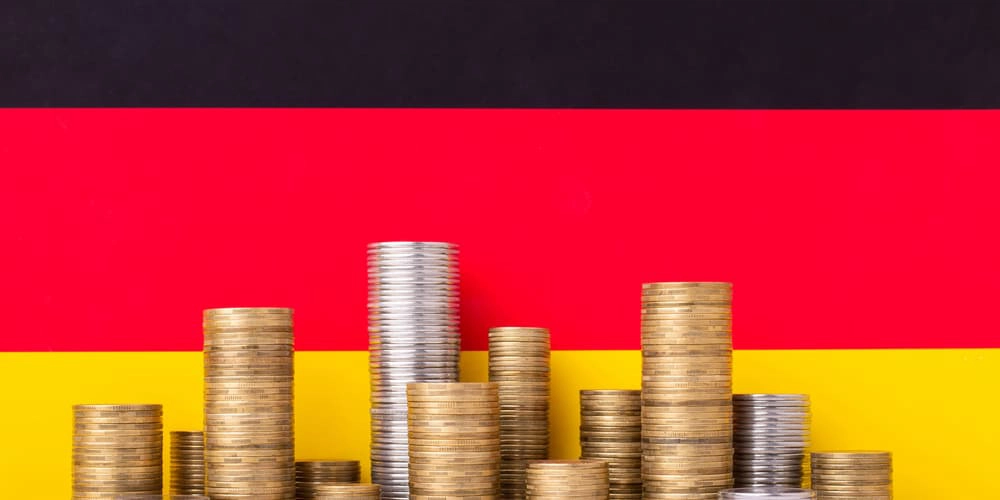 Eine deutsche Flagge und Münzen als Symol für staatliche Eigenheimförderung