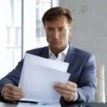 Ein Mann liest Dokumente, um die Vorlasten eines Hauses zu prüfen
