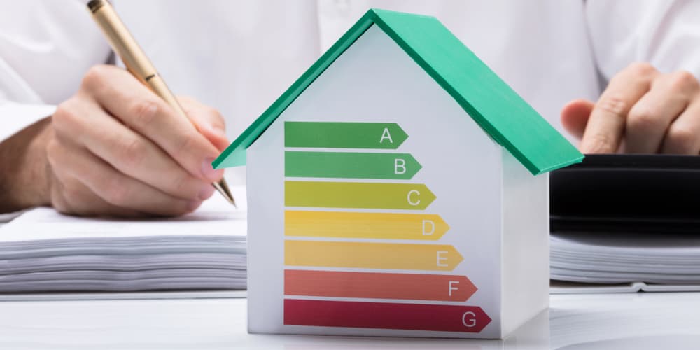 Ein Modellhaus mit Effizienzklassen als Symbol für energetische Sanierung