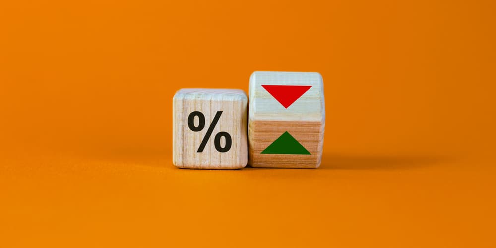 2 Holzwürfel mit Prozentzeichen und Pfeil als Symbole für das Zinsänderungsrisiko