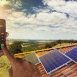 Solarpanels auf einem Dach und ein Taschenrechner, wie funktioniert die Photovoltaik-Finanzierung?